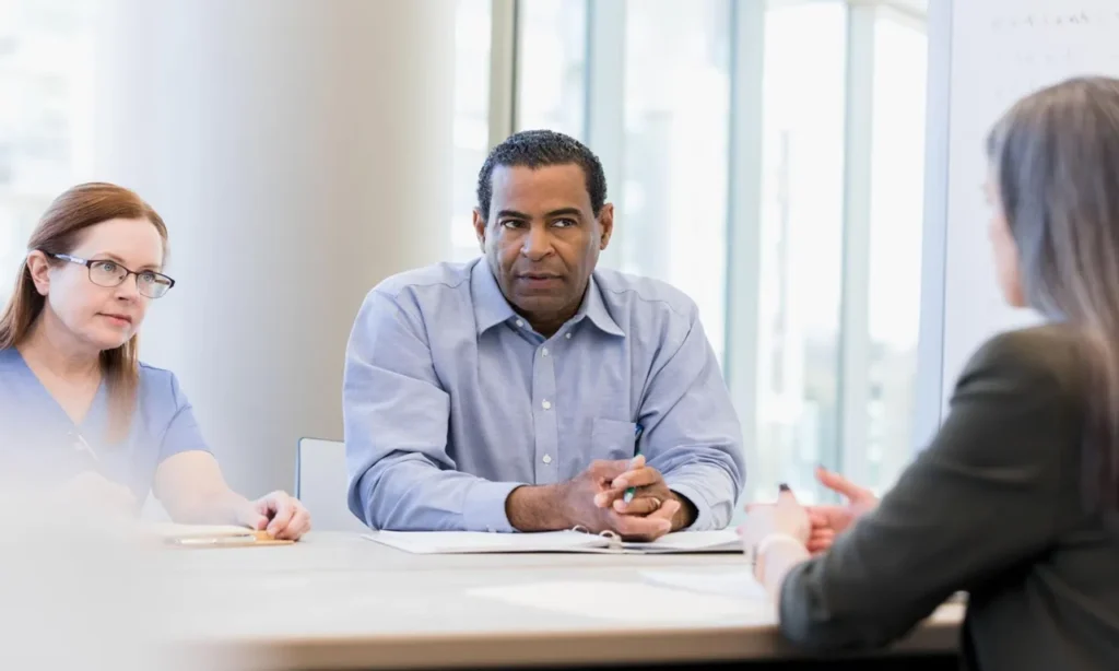 Legal help for surgical malpractice case attorney reviewing medical records with an injured patient seeking compensation after surgical negligence.
